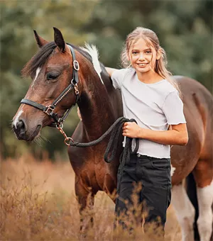 Mädchen führt geschecktes Pferd